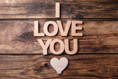 Photo of Phrase I Love You and heart on wooden background, flat lay