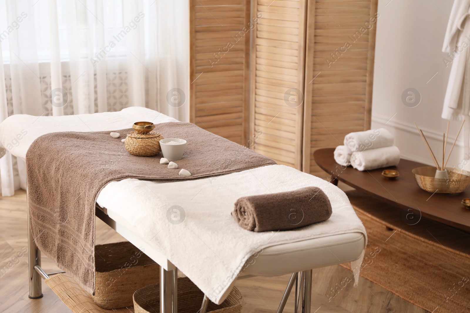 Photo of Stylish room interior with massage table in spa salon