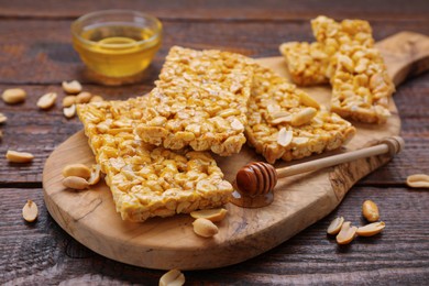 Photo of Delicious peanut bars (kozinaki) and ingredients on wooden table