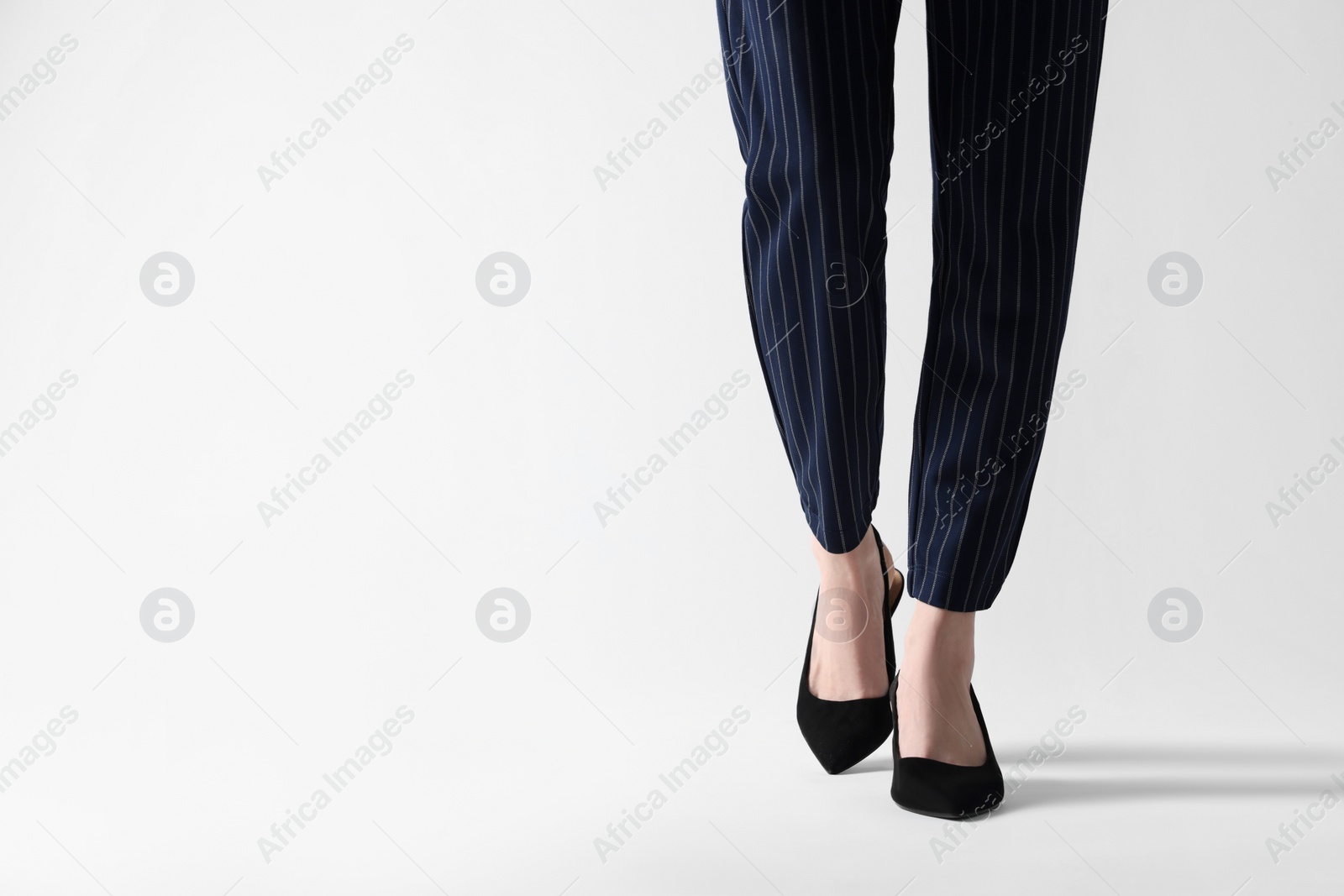 Photo of Businesswoman in black shoes on white background, closeup