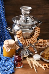 Photo of Traditional Russian samovar and treats on wooden table