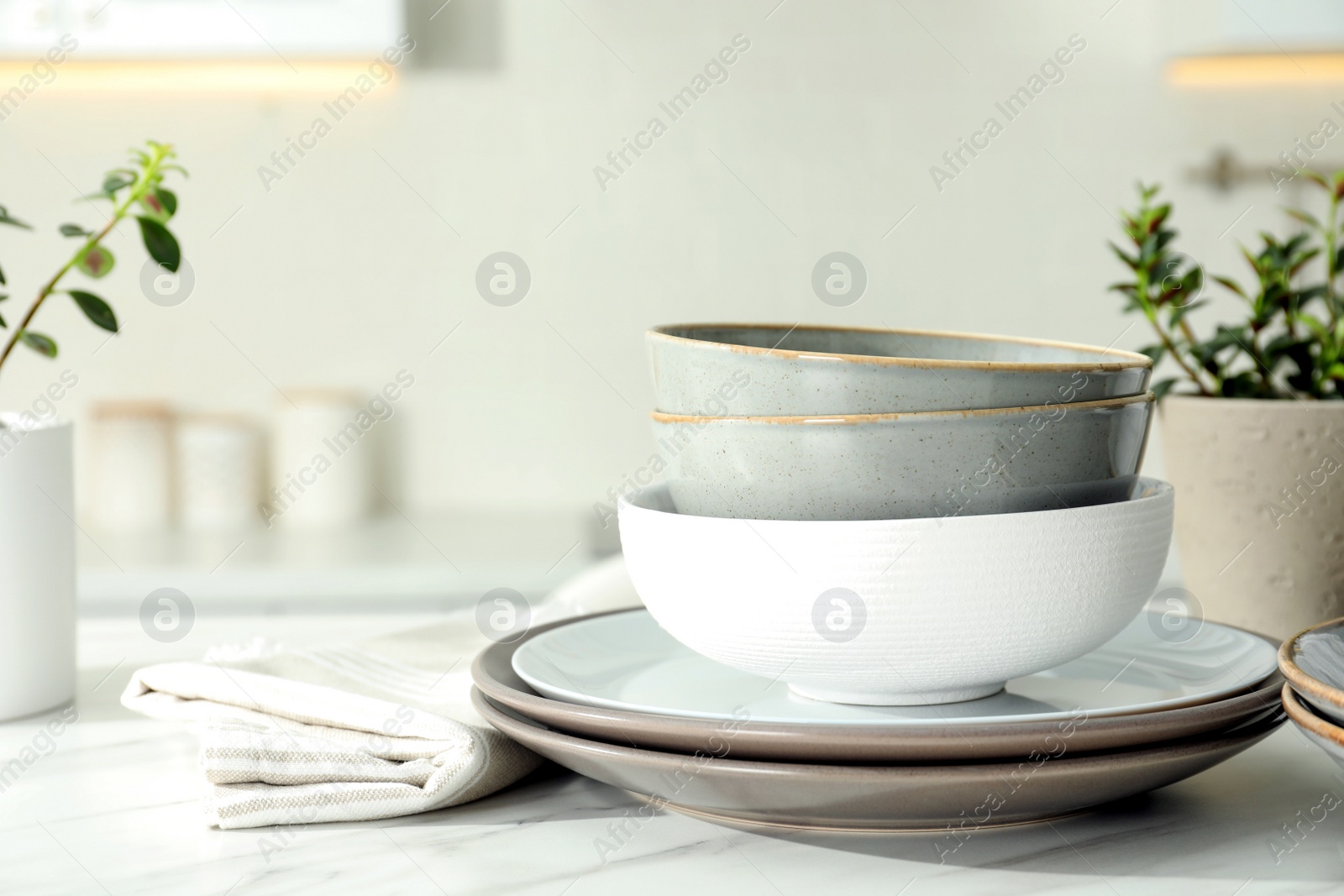 Photo of Set of beautiful ceramic tableware on white table in kitchen. Space for text