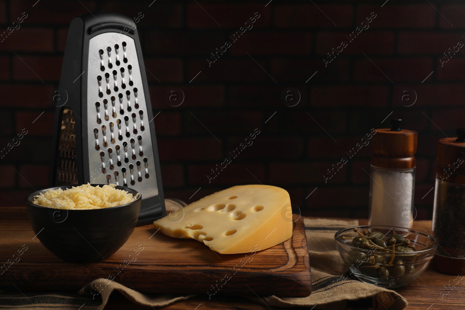 Photo of Cheese, grater and spices on wooden table