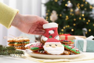 Photo of Woman with decorated Christmas cookie at table, closeup