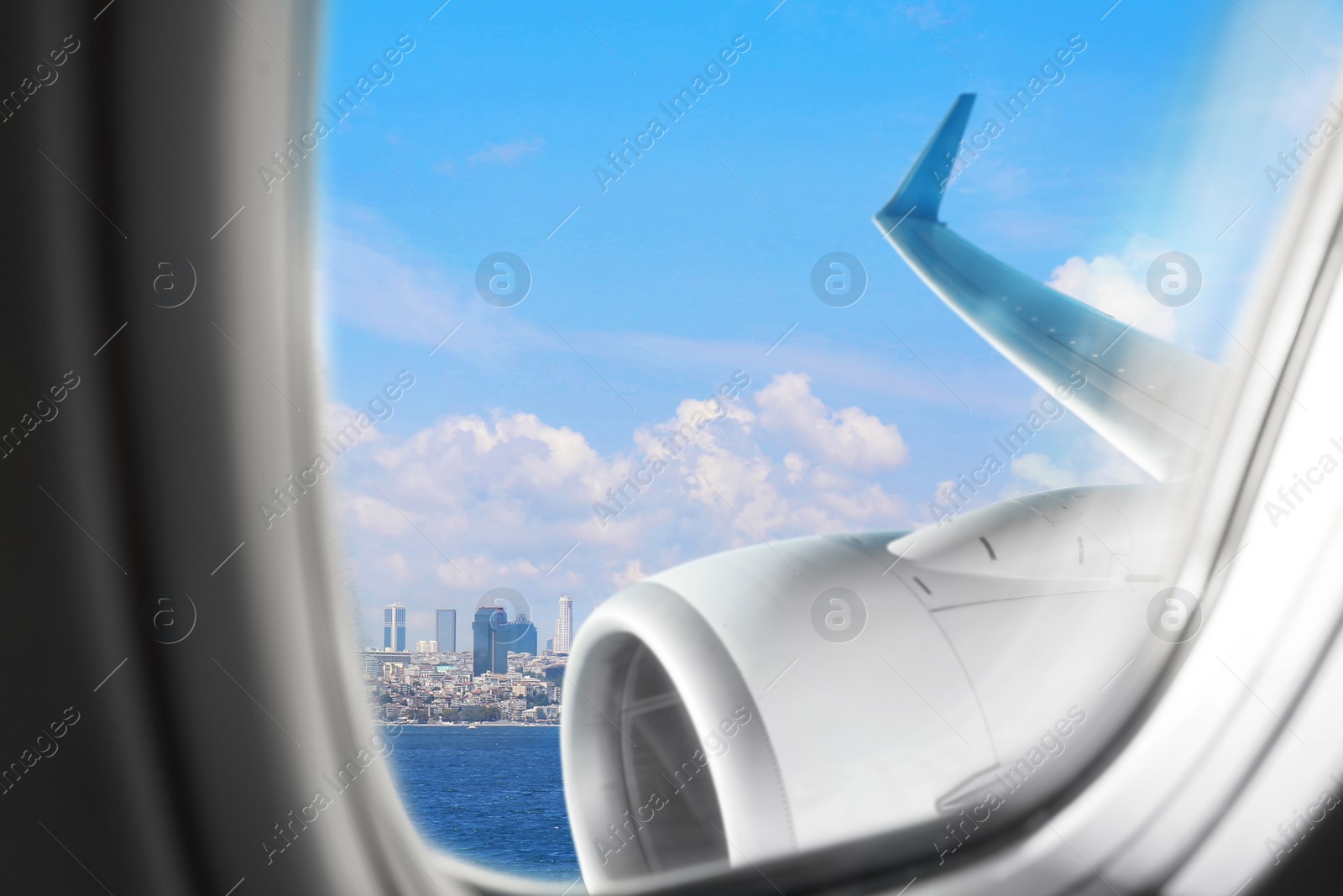 Image of Beautiful view of city and sea through airplane window during flight