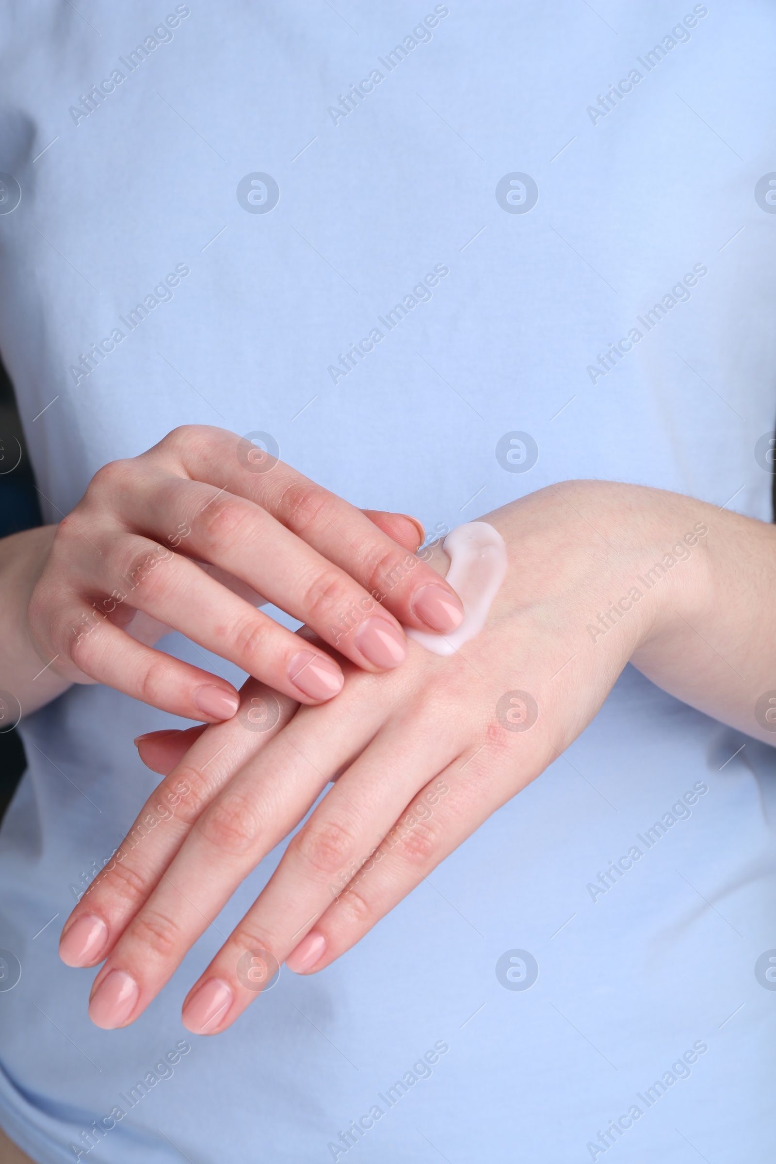 Photo of Woman applying cream on her hands, closeup