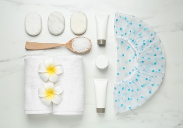 Photo of Flat lay composition with shower cap and toiletries on white marble background