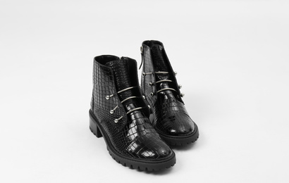 Photo of Stylish black leather ankle boots isolated on white