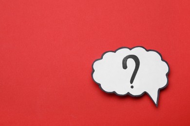 Photo of Paper speech bubble with question mark on red background, top view. Space for text