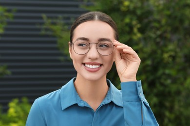 Portrait of beautiful woman in glasses on blurred background. Attractive lady smiling and posing for camera