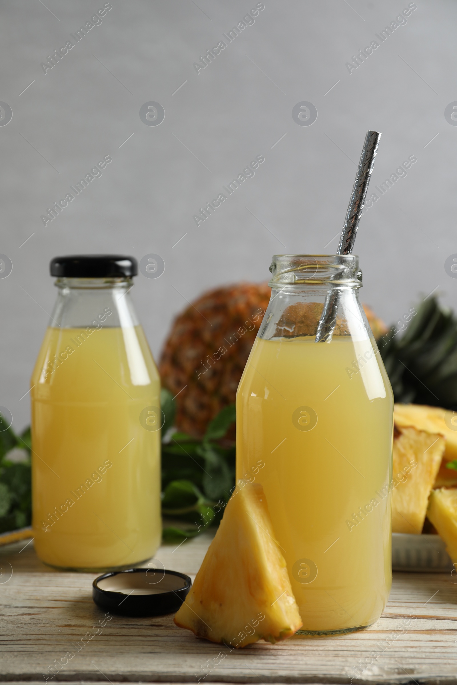 Photo of Delicious pineapple juice and fresh fruit on white table