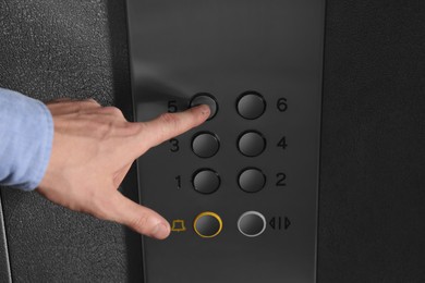 Photo of Man choosing floor in elevator, closeup view