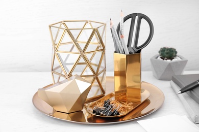 Photo of Stylish holder for stationery with office supplies and decorative elements on white wooden table