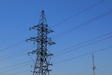 Photo of High voltage tower against blue sky on sunny day