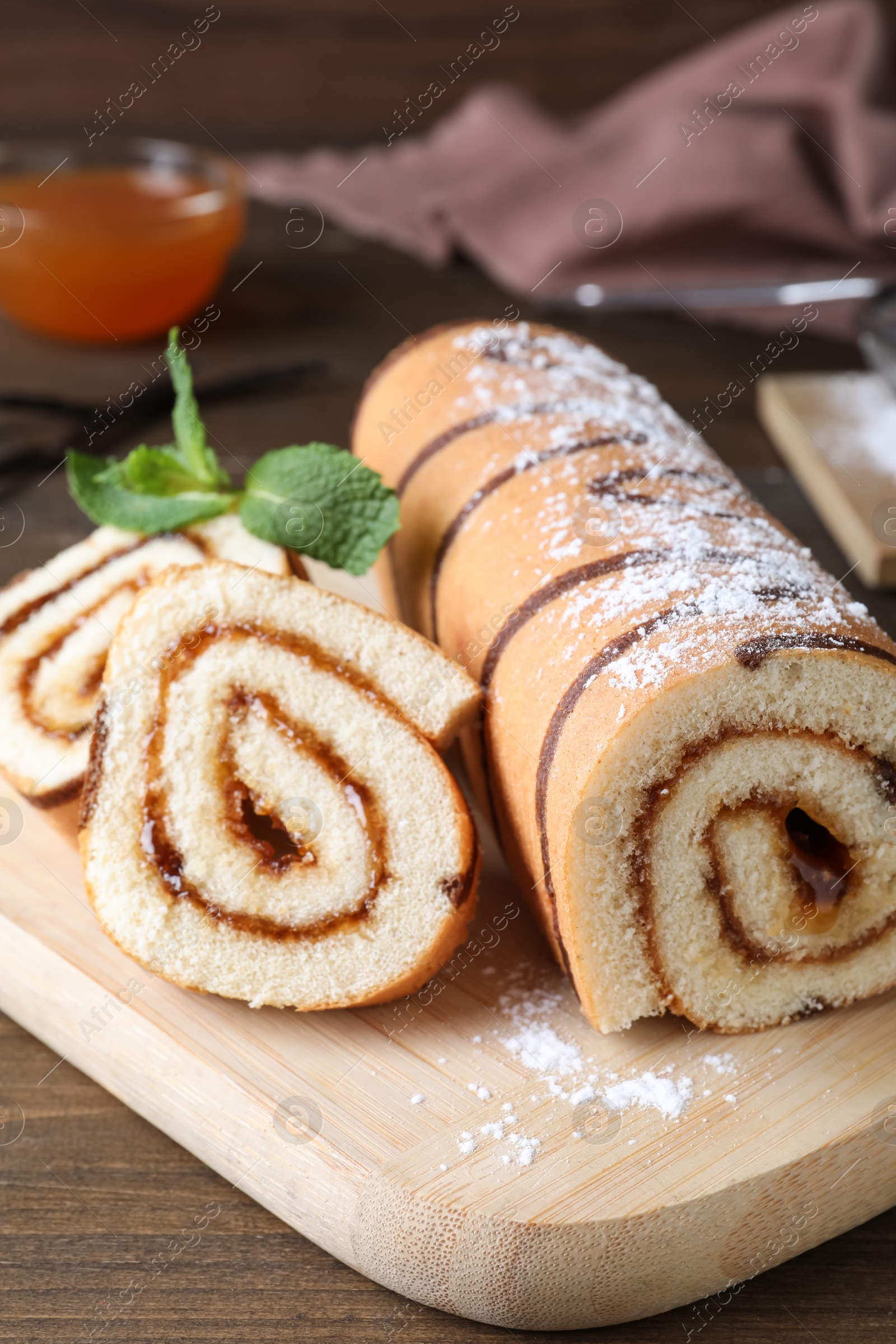 Photo of Tasty cake roll with jam on wooden table
