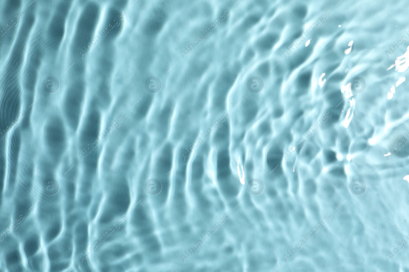 Photo of Closeup view of water with rippled surface on turquoise background