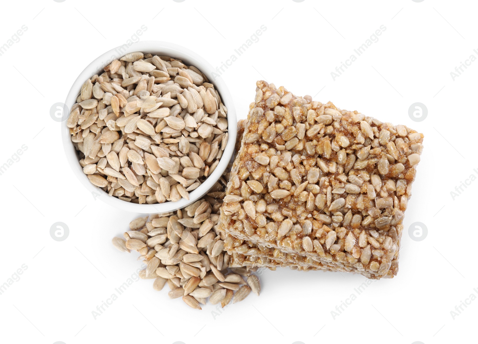 Photo of Delicious sweet kozinaki bars and sunflower seeds on white background, top view