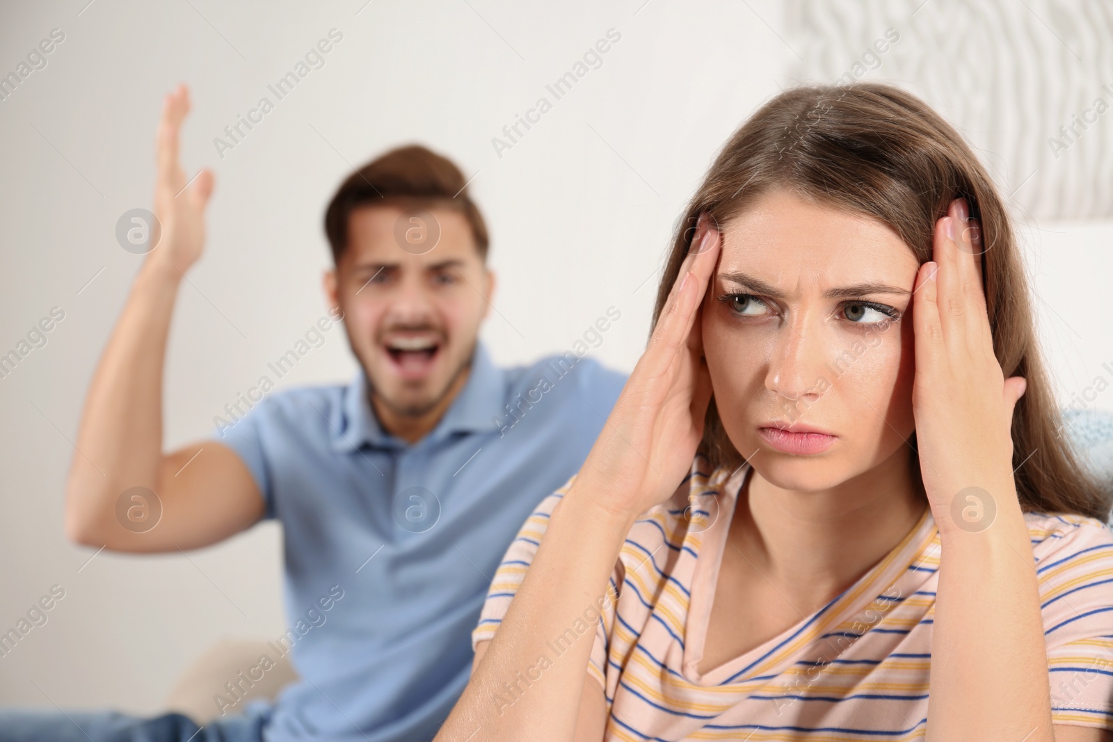 Photo of Young couple arguing in living room. Relationship problems