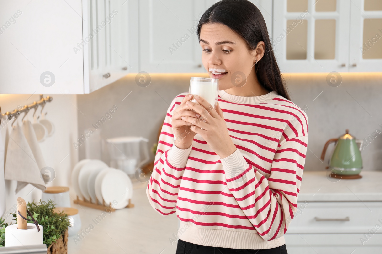 Photo of Cute woman with milk mustache drinking tasty dairy drink in kitchen. Space for text