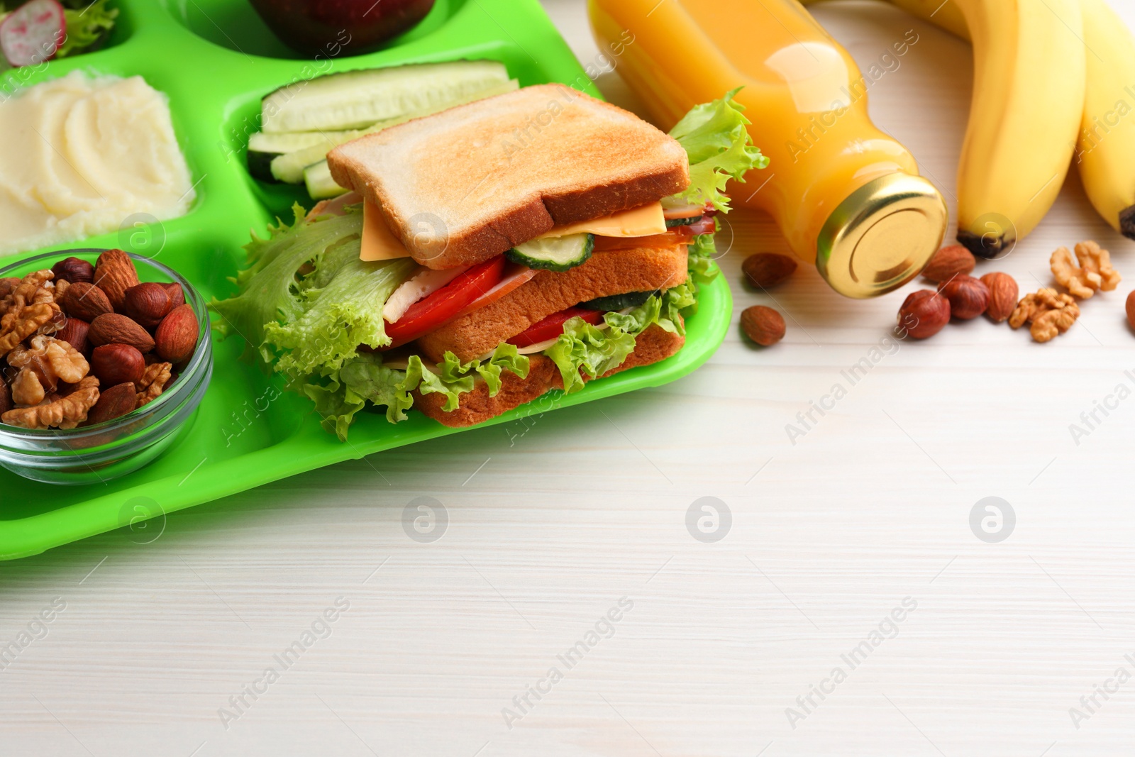 Photo of Serving tray of healthy food and space for text on white wooden table, closeup. School lunch