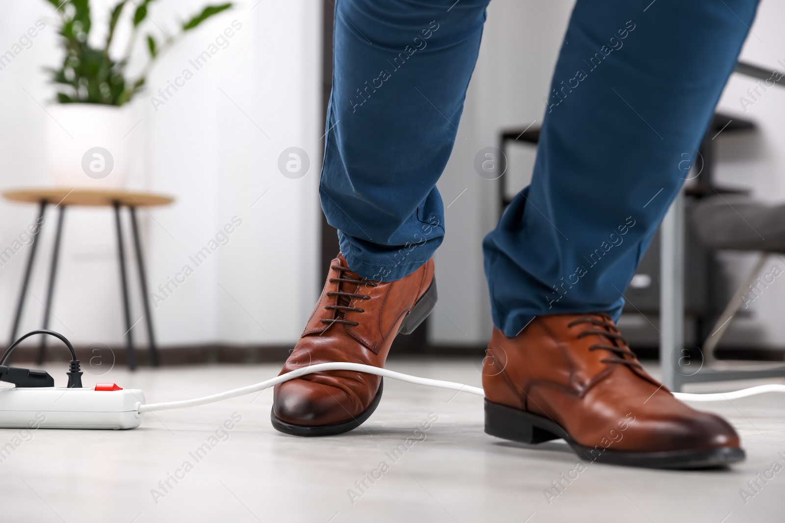 Photo of Man tripping over cord in office, closeup