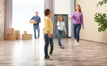 Happy family and pile of moving boxes in their new house