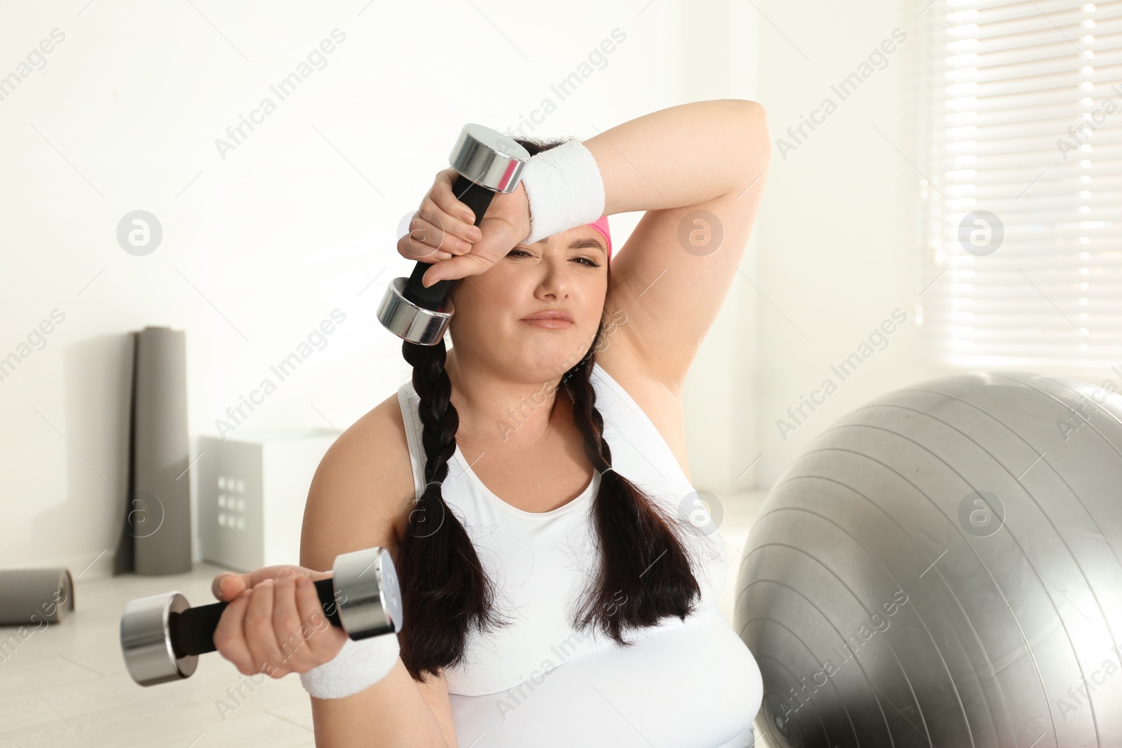 Photo of Lazy overweight woman with dumbbells at gym