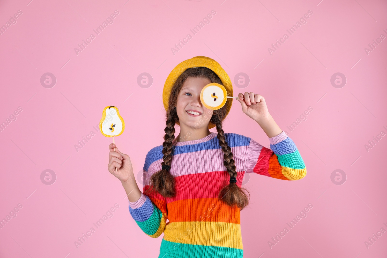 Photo of Little girl with candies on color background