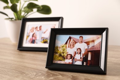 Photo of Frames with family photos on wooden table
