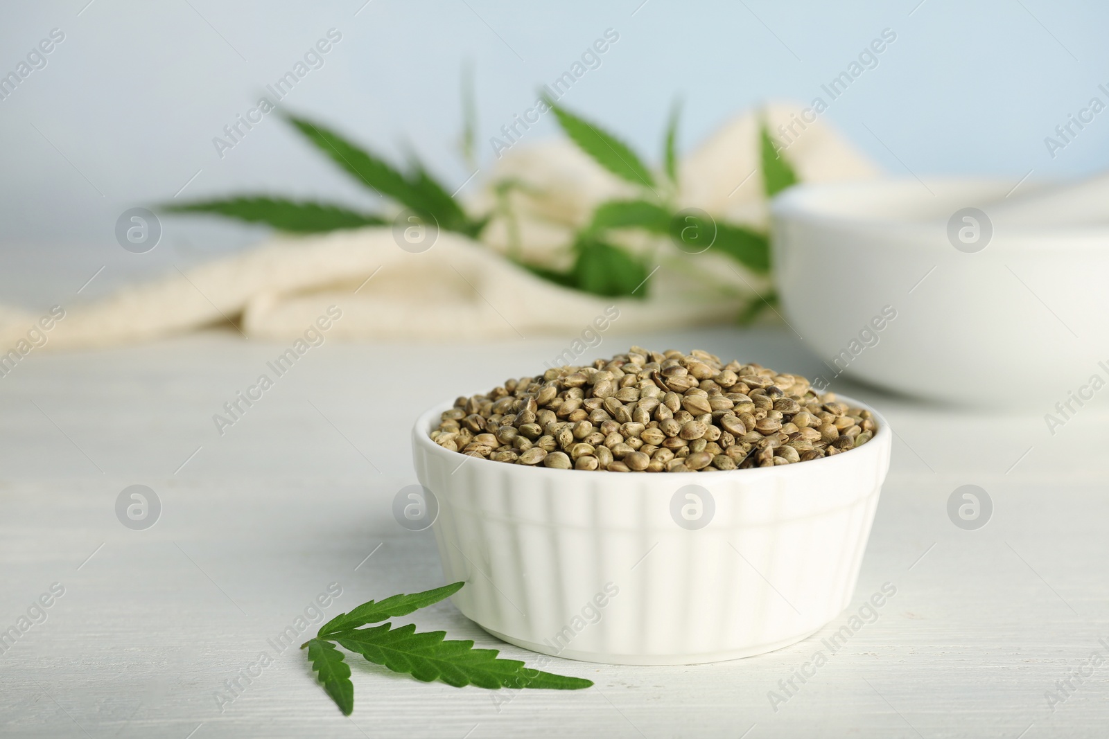 Photo of Ceramic bowl with hemp seeds on table