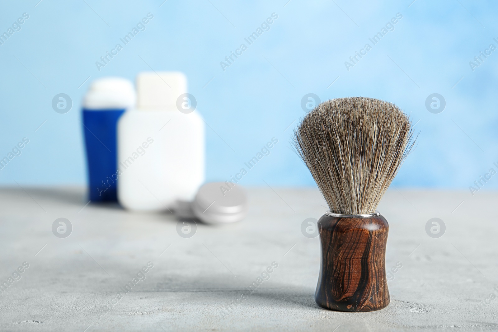 Photo of Shaving brush on table against blurred background with space for text