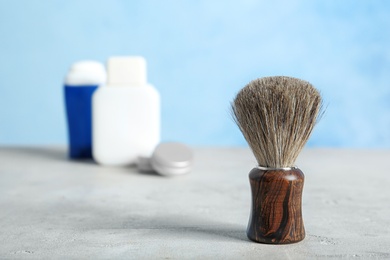 Shaving brush on table against blurred background with space for text