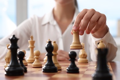 Photo of Woman playing chess during tournament at chessboard, closeup