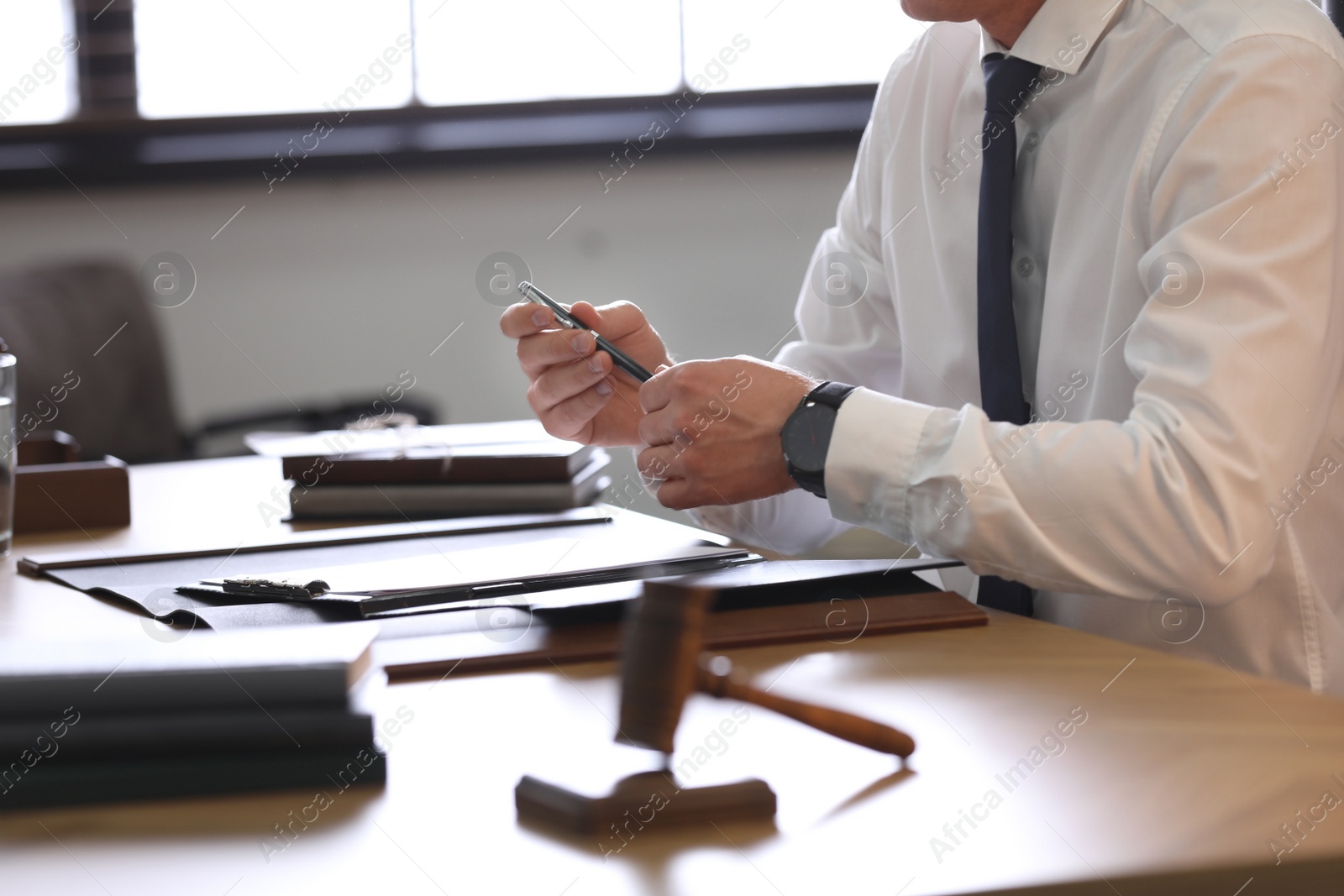 Photo of Male lawyer working at table in office, closeup