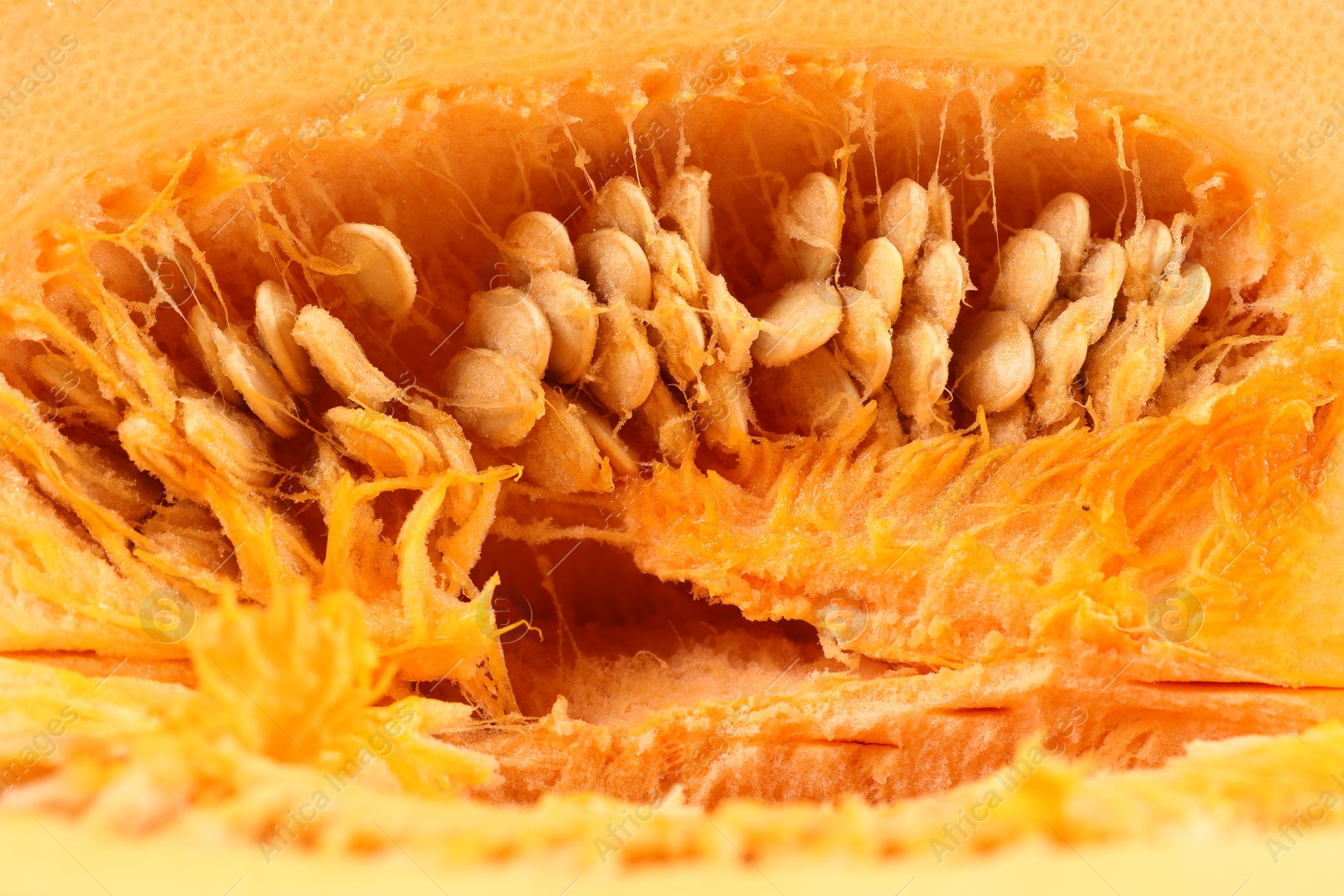 Photo of Cut fresh ripe pumpkin with seeds as background, closeup