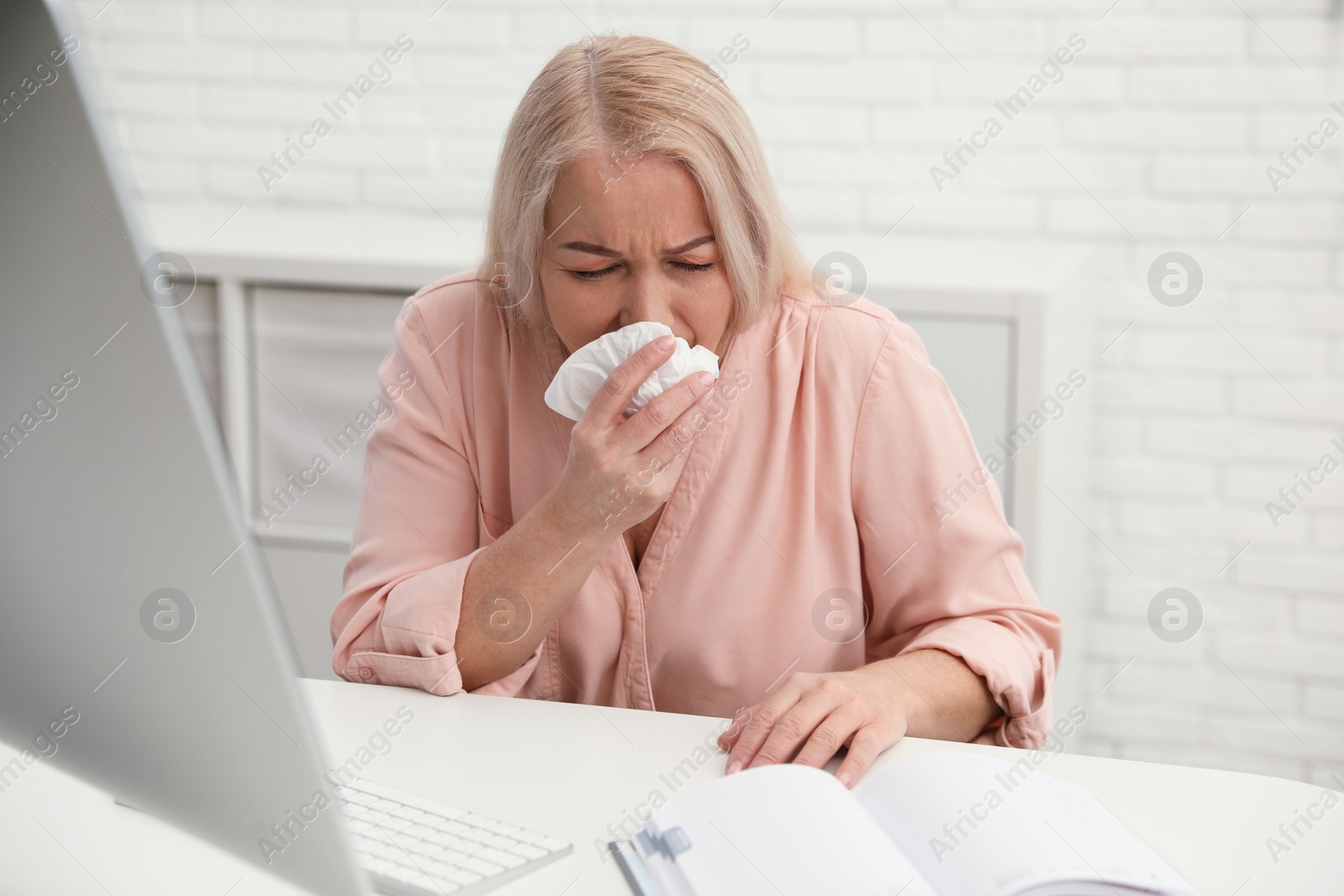 Photo of Sick mature woman at workplace. Dangerous virus