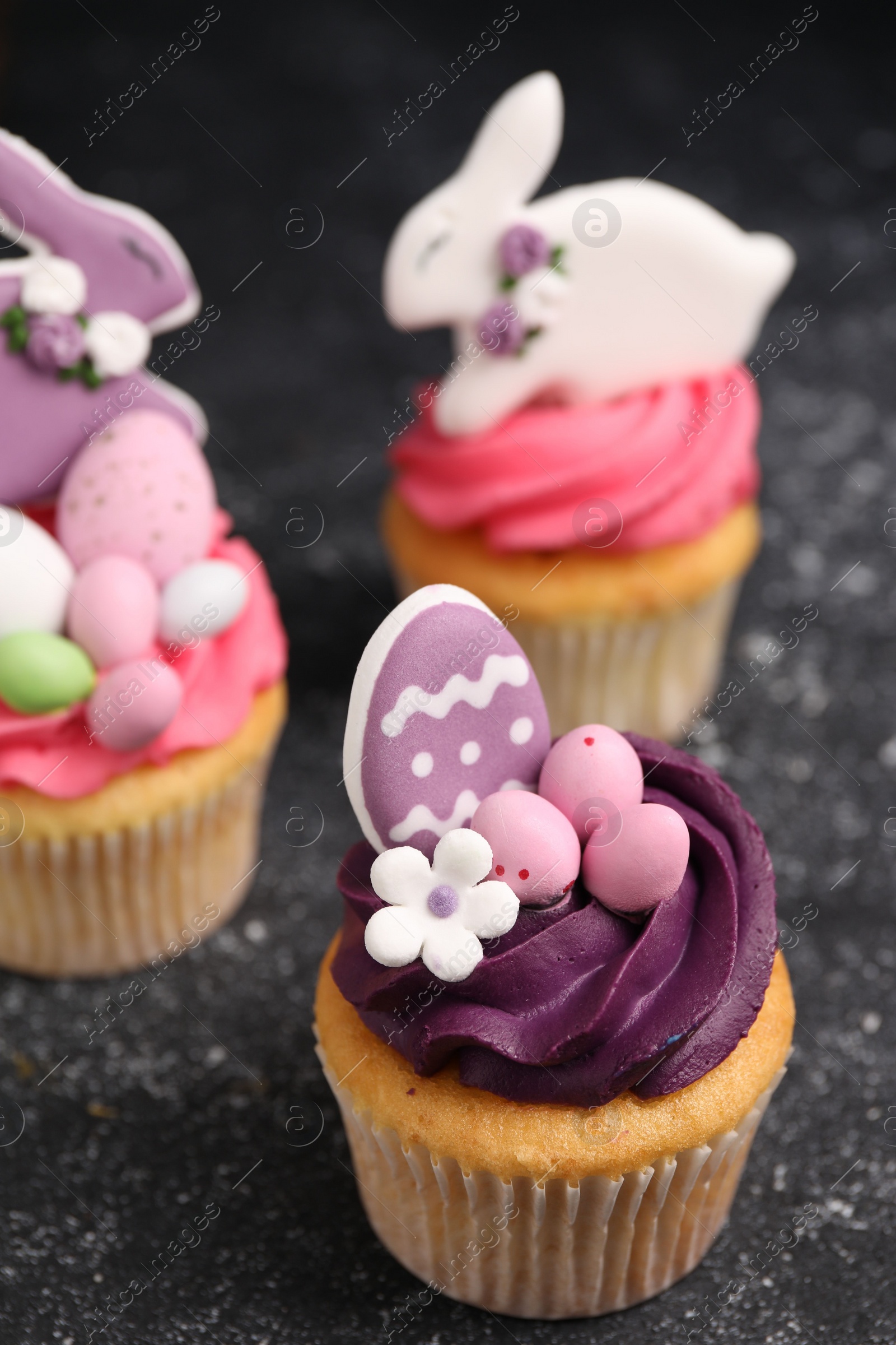 Photo of Tasty decorated Easter cupcakes on grey table