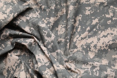 Photo of Texture of crumpled camouflage fabric as background, top view