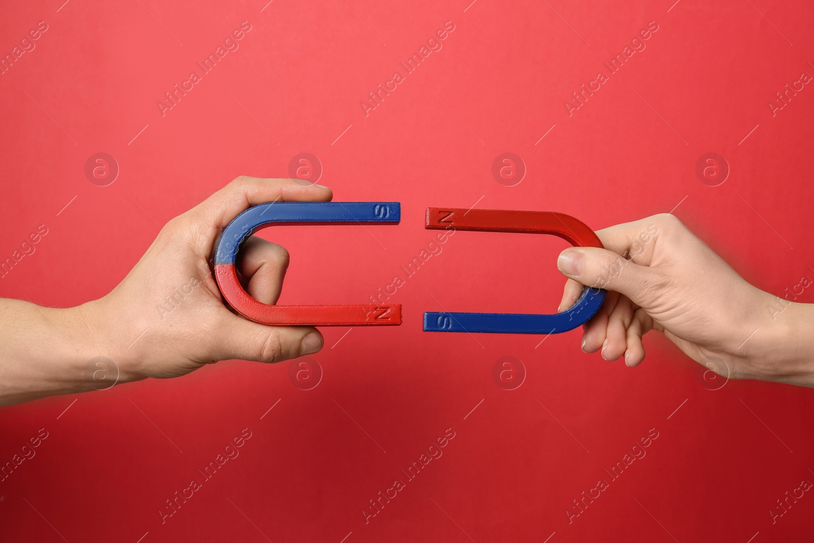 Photo of People holding magnets on color background, closeup