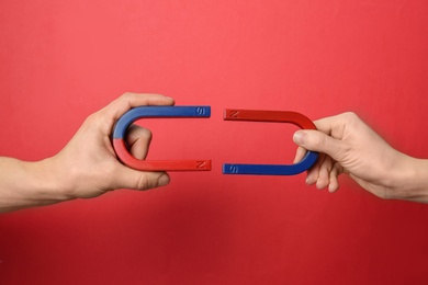 People holding magnets on color background, closeup