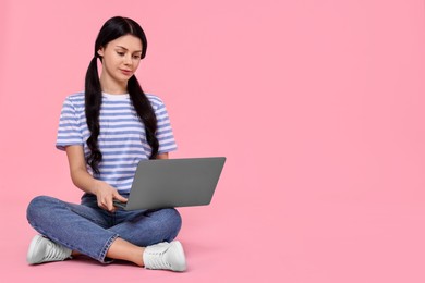 Photo of Student with laptop sitting on pink background. Space for text