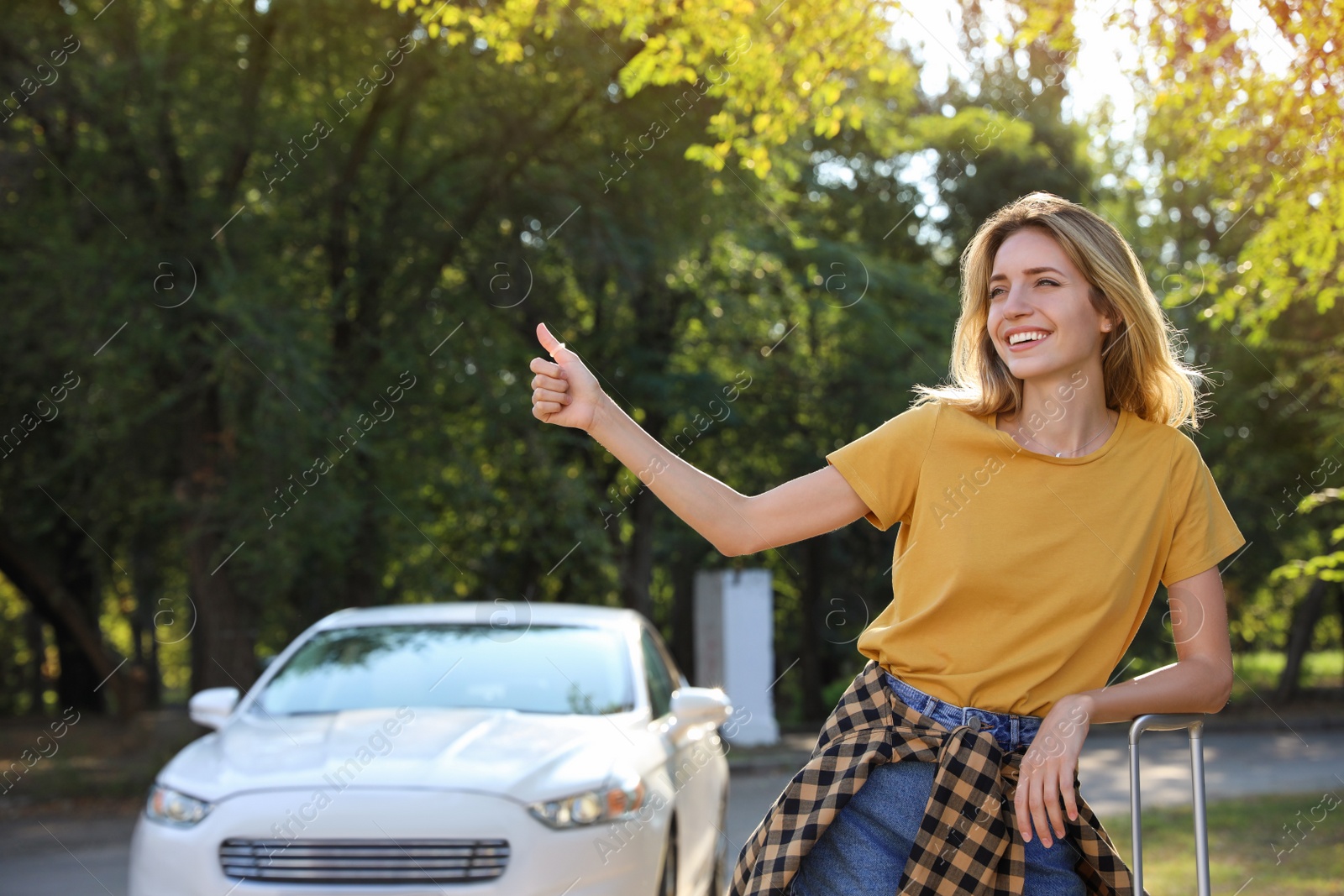 Photo of Young woman hitchhiking taxi on city street