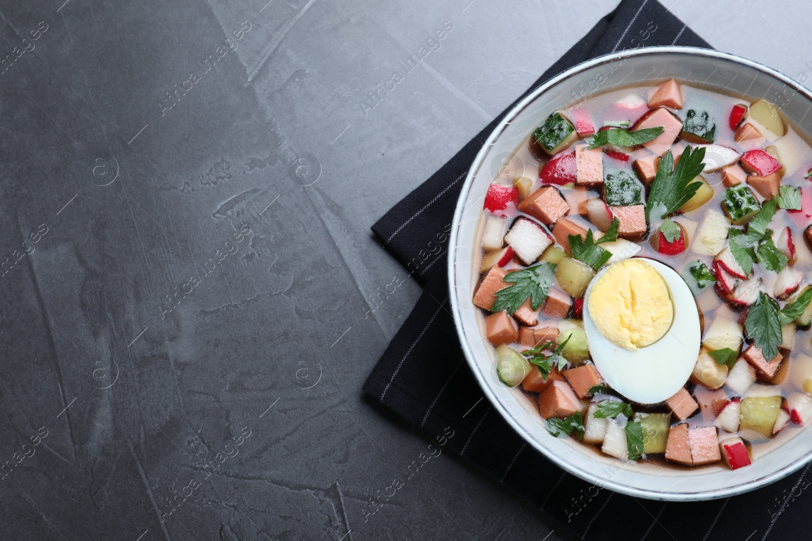 Photo of Delicious cold okroshka with kvass on grey table, top view and space for text. Traditional Russian summer soup