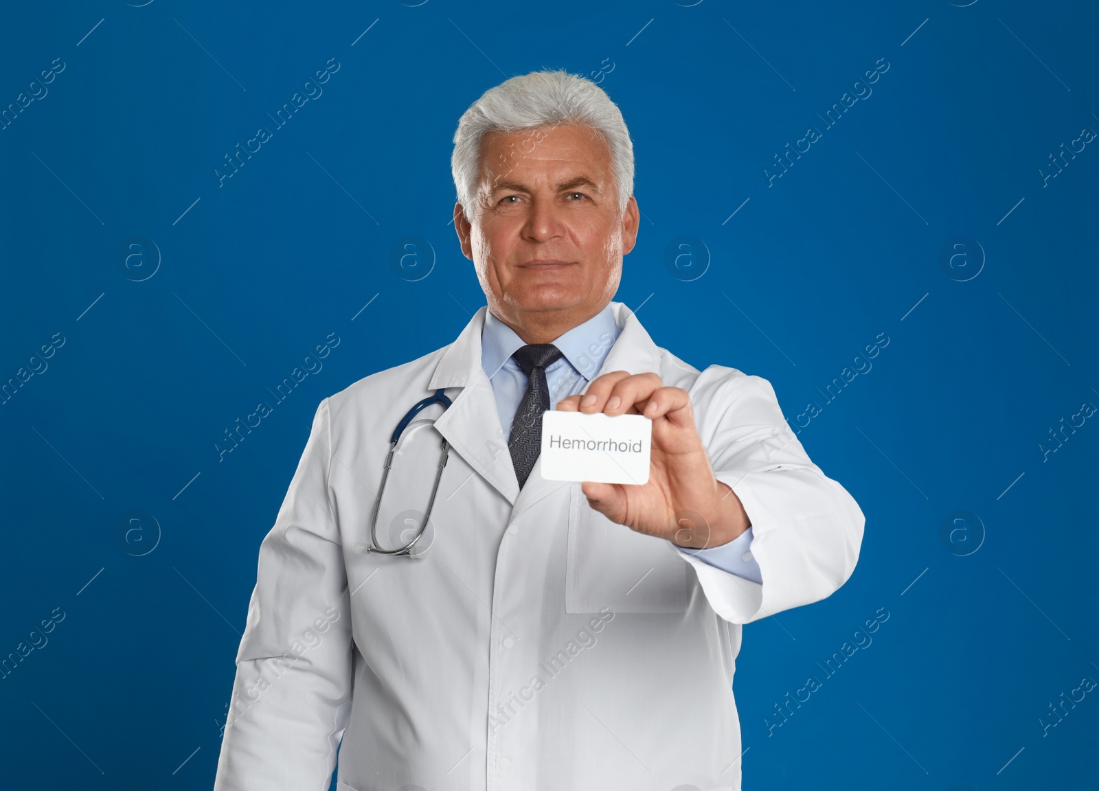 Photo of Doctor holding business card with word HEMORRHOID on blue background