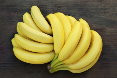 Photo of Ripe yellow bananas on wooden table, flat lay