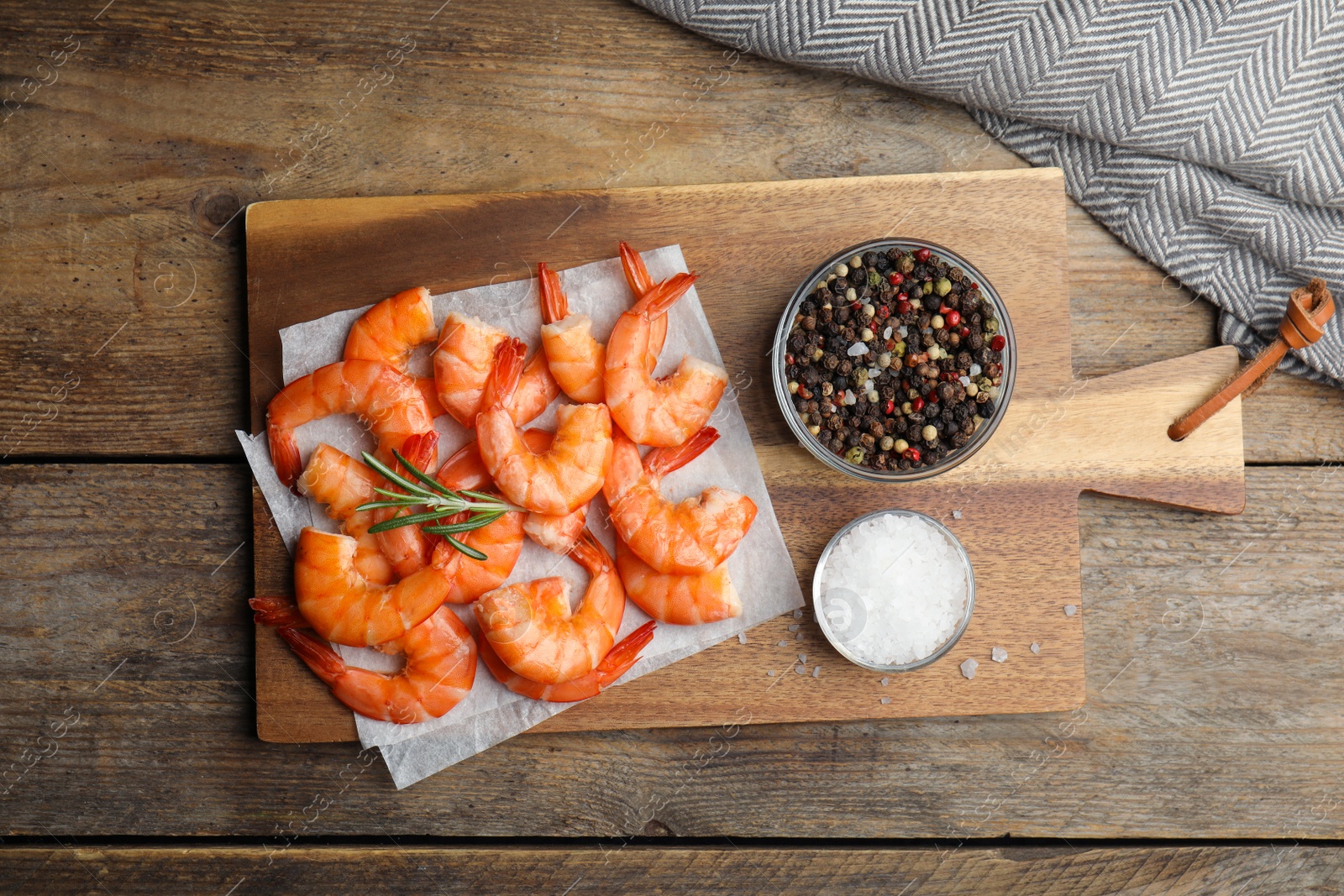 Photo of Delicious cooked shrimps with rosemary and spices on wooden table, flat lay