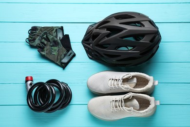 Photo of Flat lay composition with different cycling accessories on turquoise wooden background