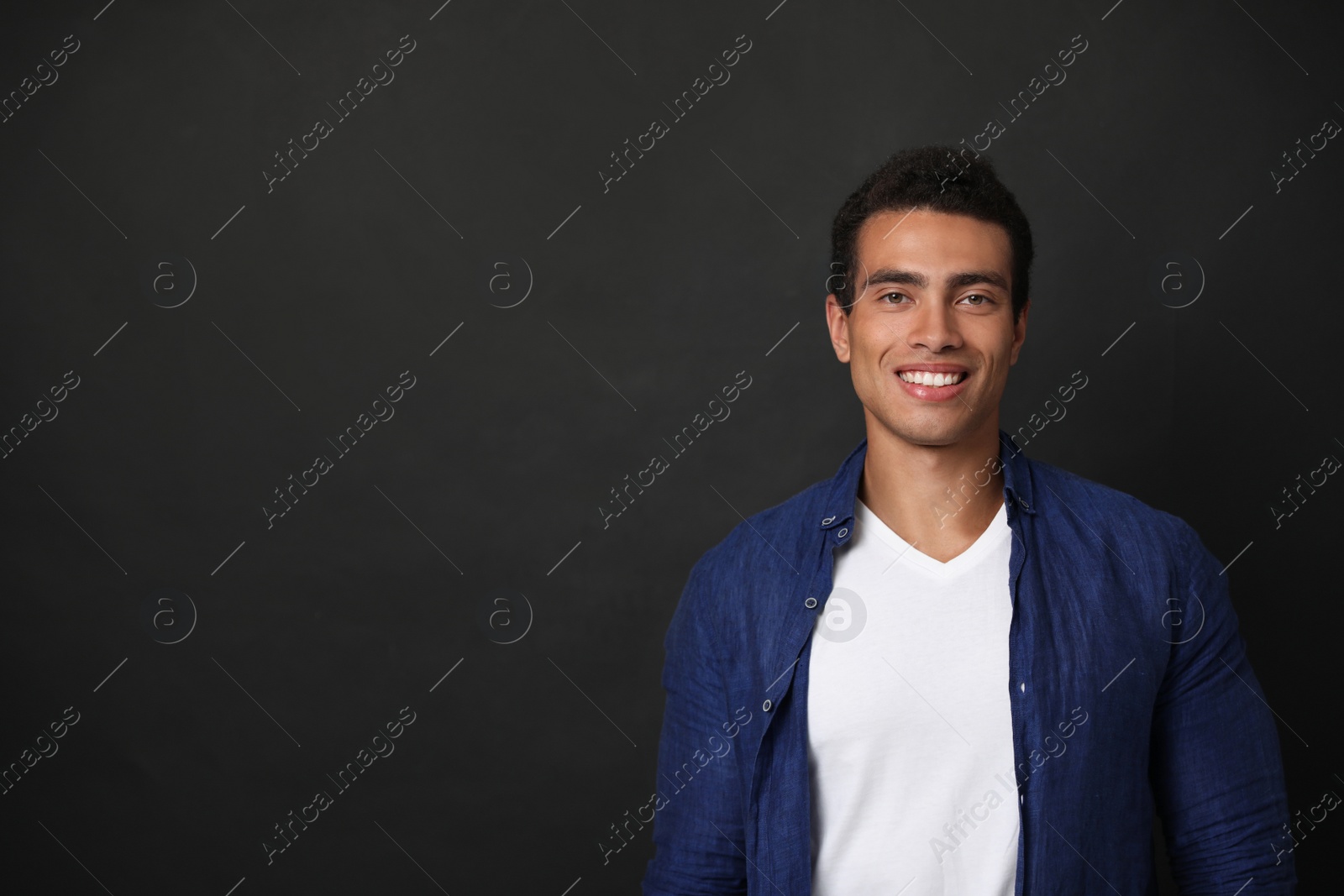 Photo of Handsome young African-American man on black background. Space for text