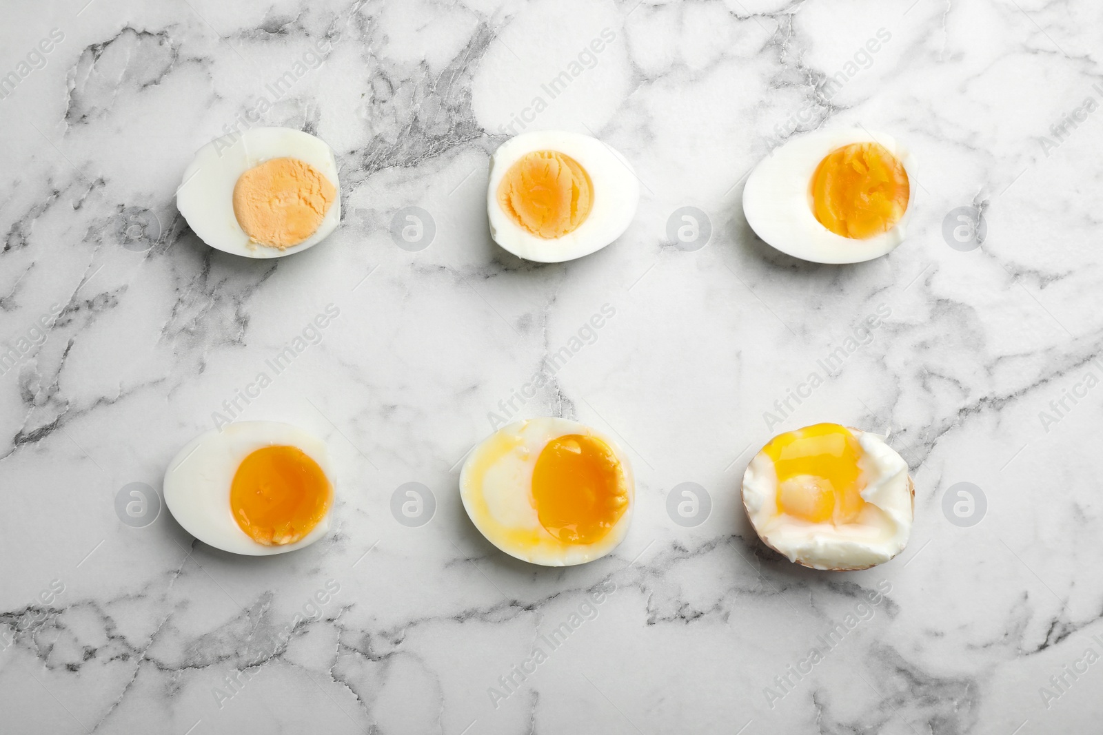 Photo of Various types of boiled eggs on marble background, flat lay. Cooking time