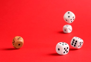 Photo of Many color game dices falling on red background